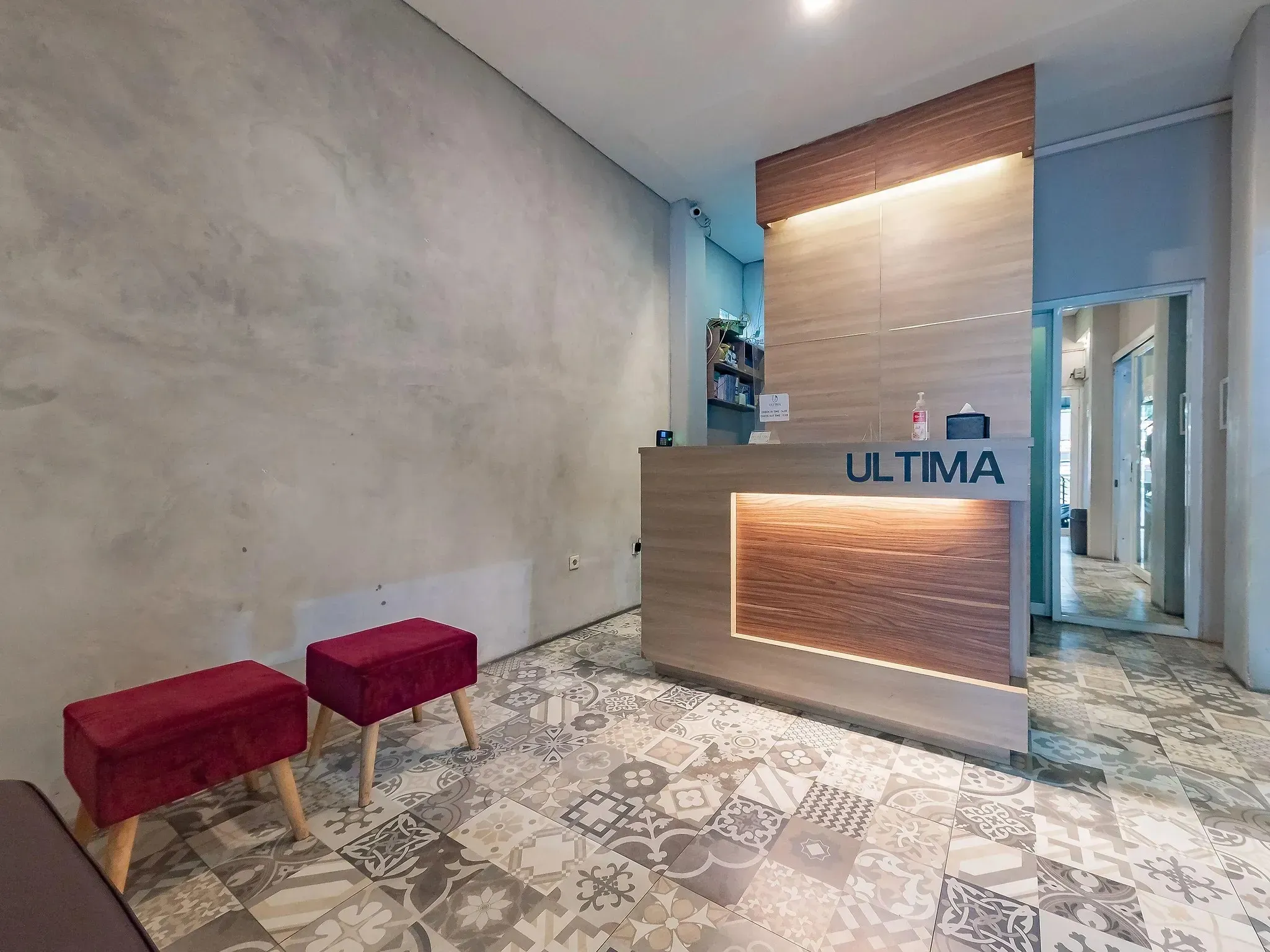 Modern reception and lobby area with Ultima sign and red chairs