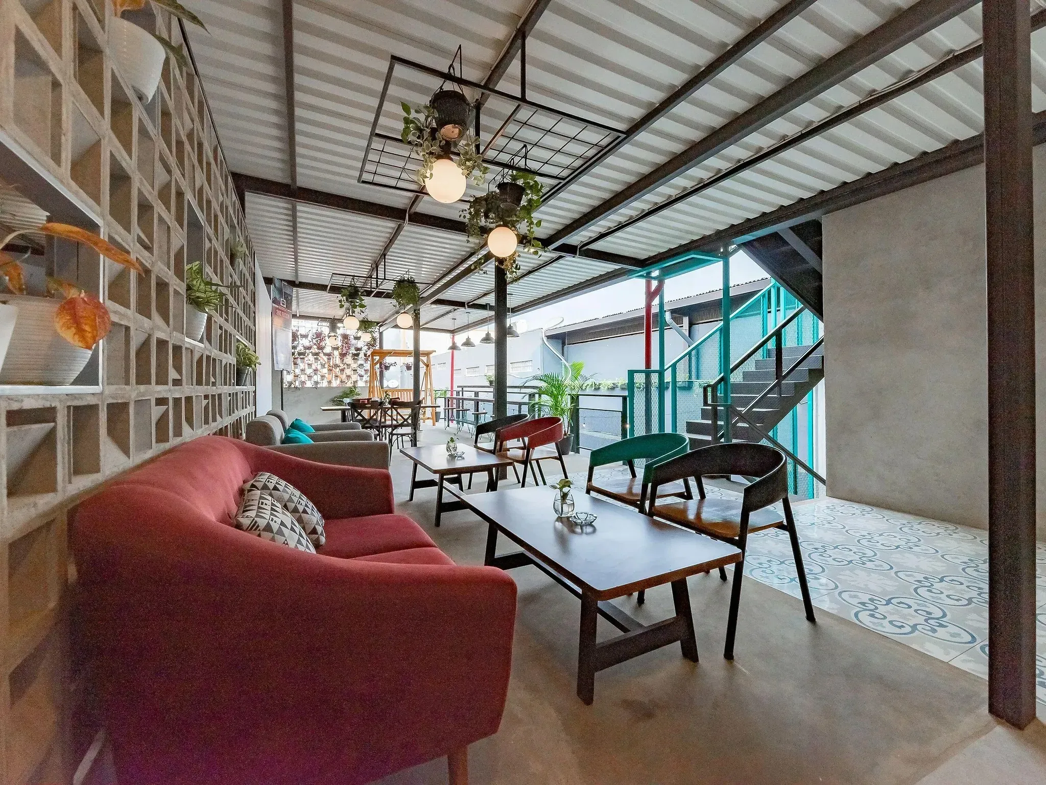 Cozy lounge corner with a red sofa against a geometric breeze-block wall