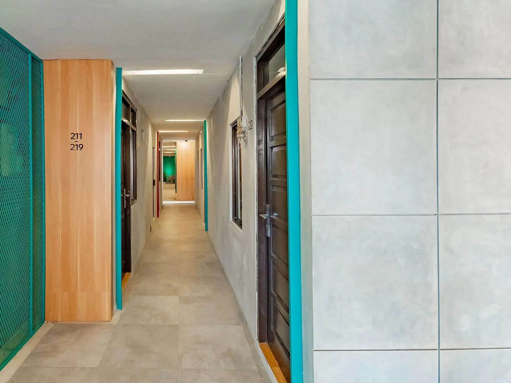 Hallway with teal-framed doors leading to the guest rooms